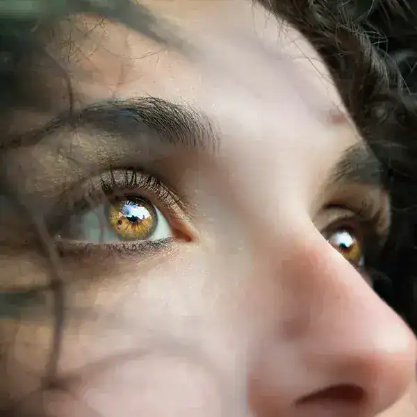 Close-up of a woman's face showing reflective eyes and natural features.