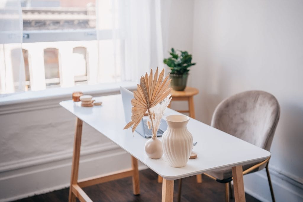 Stylish room with a table, vases, and a plant near a window.