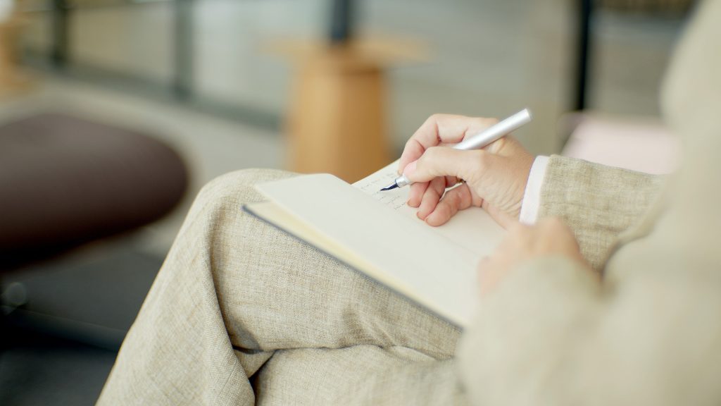 Professional psychologist writing notes in a clinical setting for ADHD assessment.